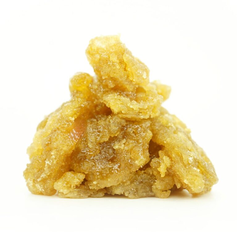 Close-up image of golden cannabis concentrate with a rich, glossy, and crystalline texture, piled in a small mound on a clean white background.