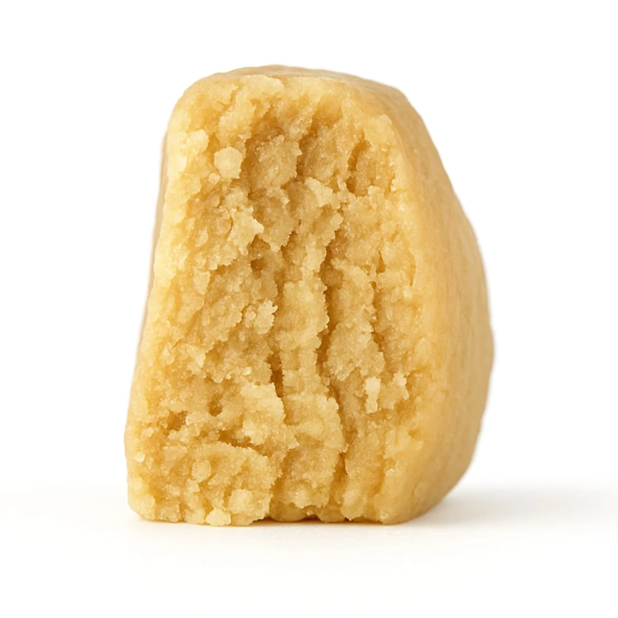 close-up of a light beige, crumbly concentrate piece displayed on a crisp white background, showing fine granular texture and natural depth with soft, even lighting.