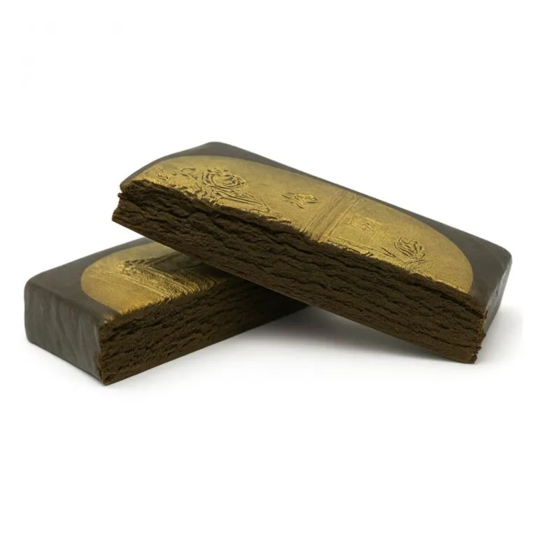 Two gold-stamped blocks of pressed hashish stacked on a white background, showcasing a smooth outer layer with embossed detailing and a crumbly interior texture.
