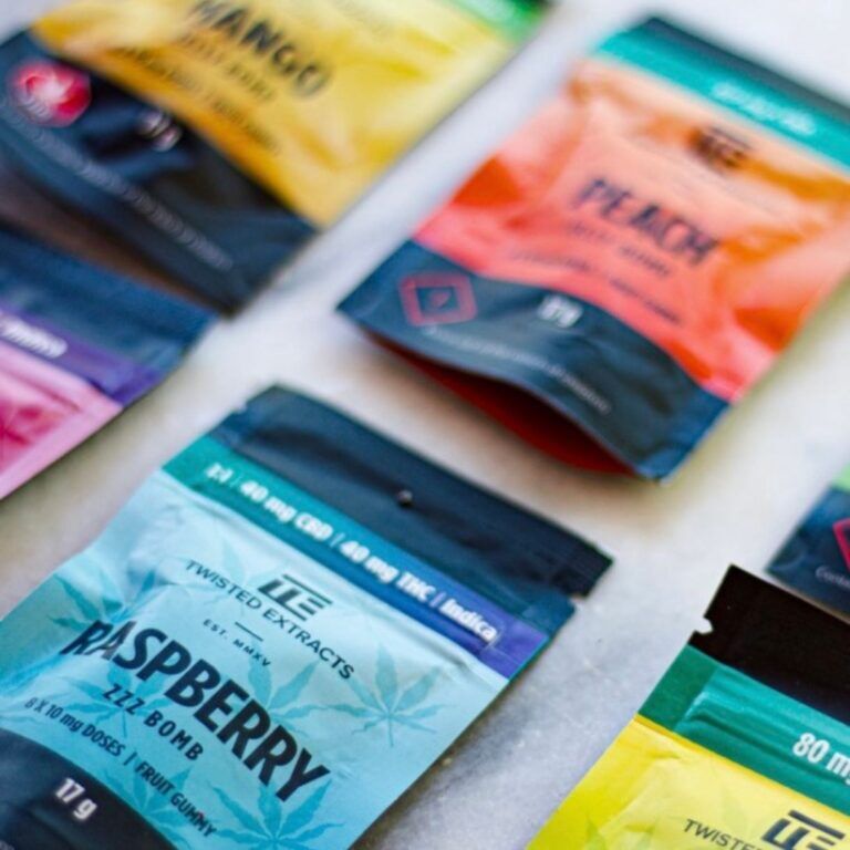 Assorted Twisted Extracts cannabis edibles including Raspberry ZZZ Bomb, Peach Jelly Bomb, and Mango Jelly Bomb displayed on a marble surface in colorful packaging.