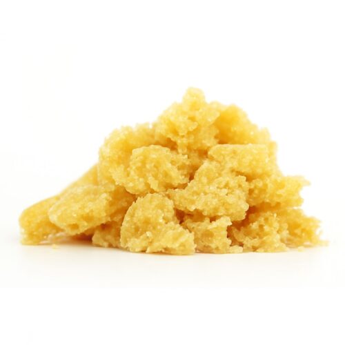 Golden-yellow cannabis crumble concentrate in a small pile on a crisp white background, captured in a close-up shot that highlights its grainy, sugar-like texture and natural matte finish.