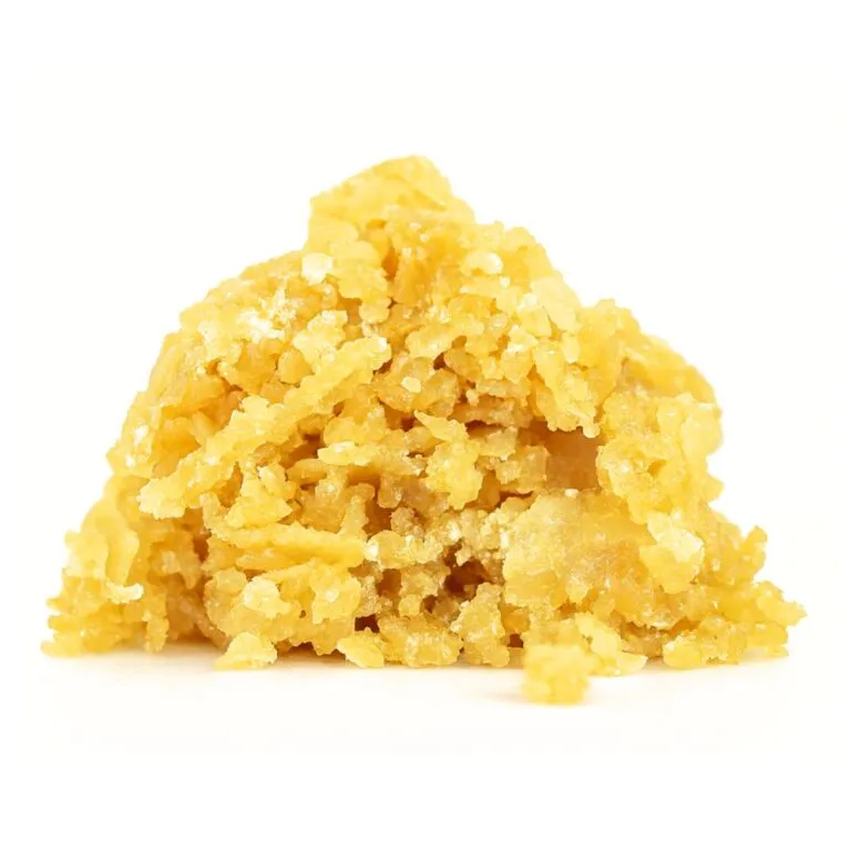 Golden cannabis crumble concentrate with a coarse, crystalline texture on a white background