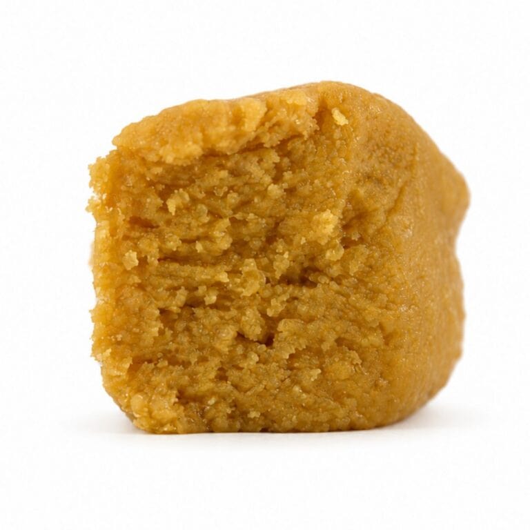 jack herer budder Close-up Pale yellow cannabis extract with a crumbly texture displayed upright on a white background