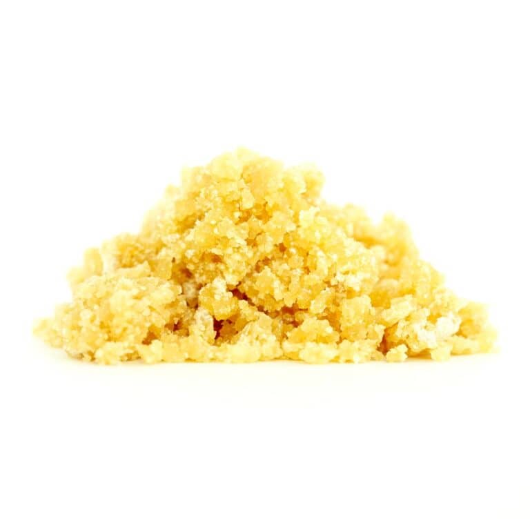 Golden cannabis sugar wax concentrate photographed on a crisp white background with visible crystal texture and natural depth