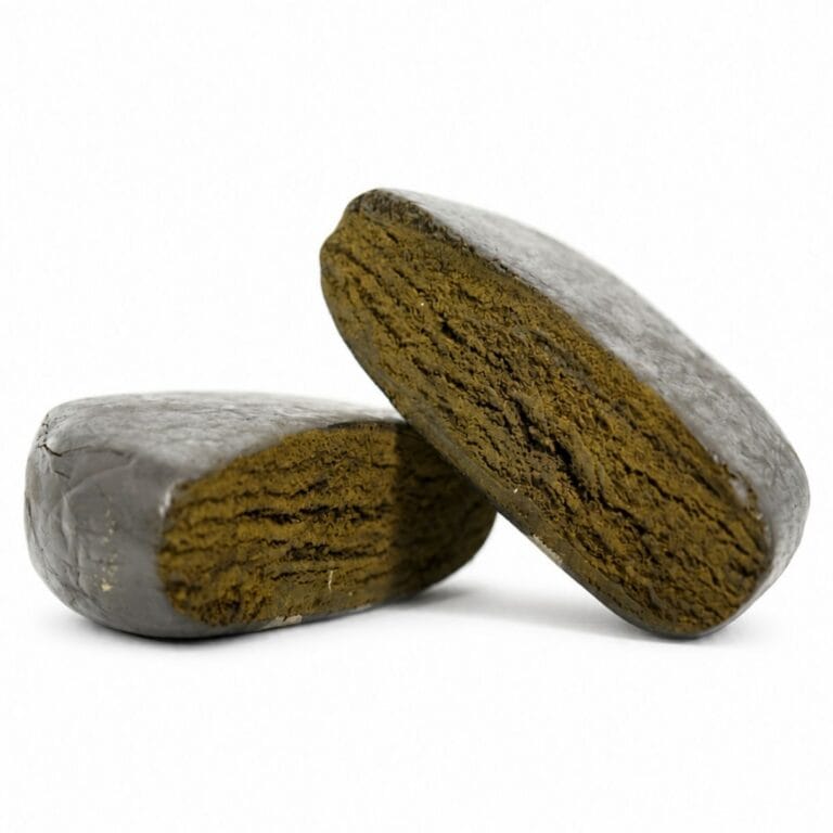 Close-up product image of pressed hash cannabis concentrate pieces with smooth outer surface and dense brown interior on white background