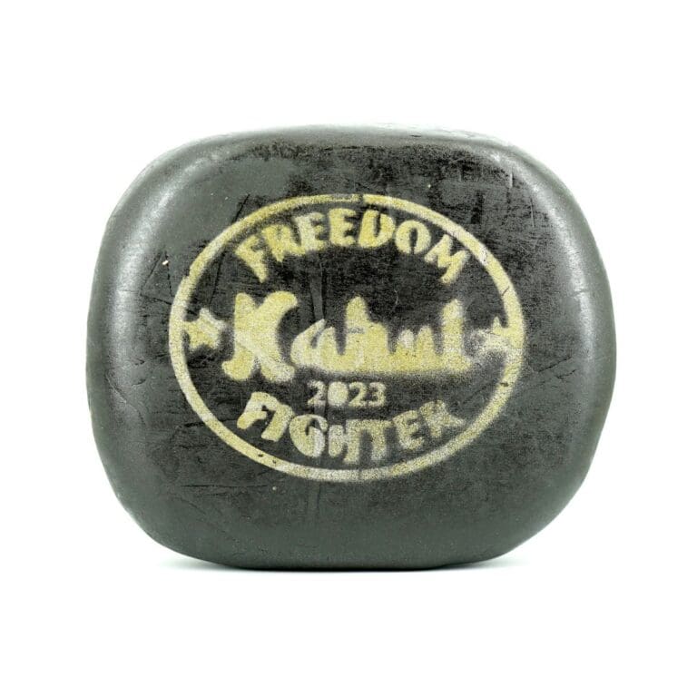 Close-up product image of pressed hash cannabis concentrate pieces with smooth outer surface and dense brown interior on white background