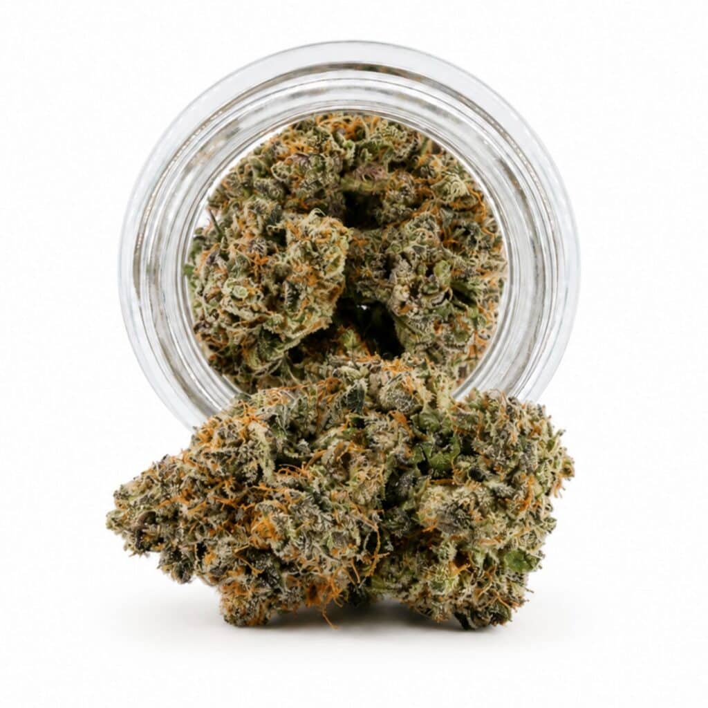 Dense cannabis flower with frosty trichomes in foreground, glass jar softly blurred on a crisp white background