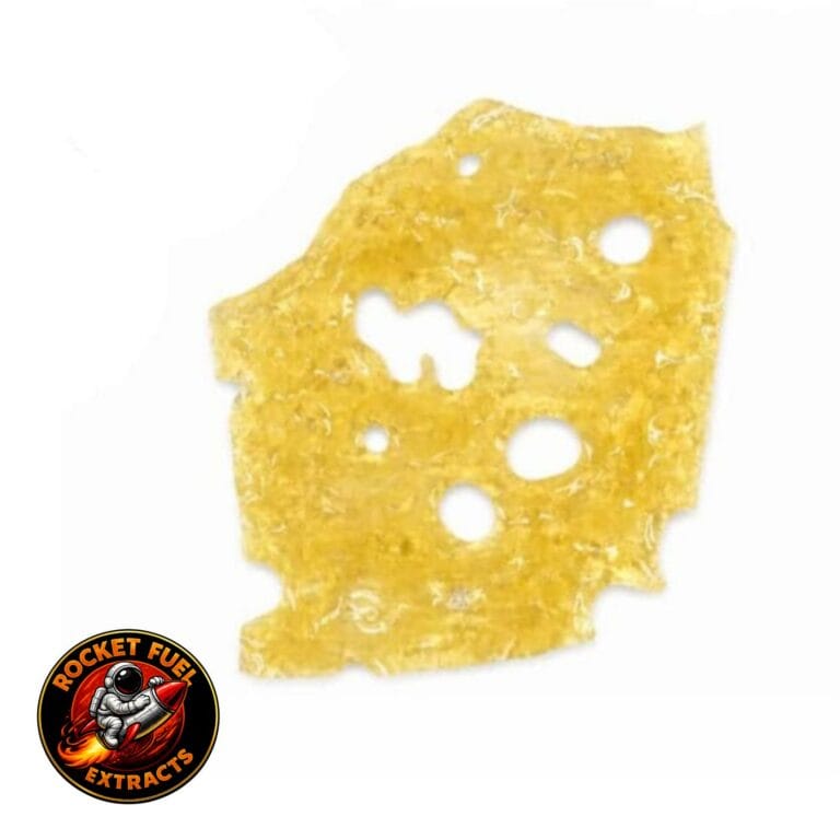Close-up of a translucent golden cannabis concentrate slab with a porous, lace-like texture on a crisp white background.