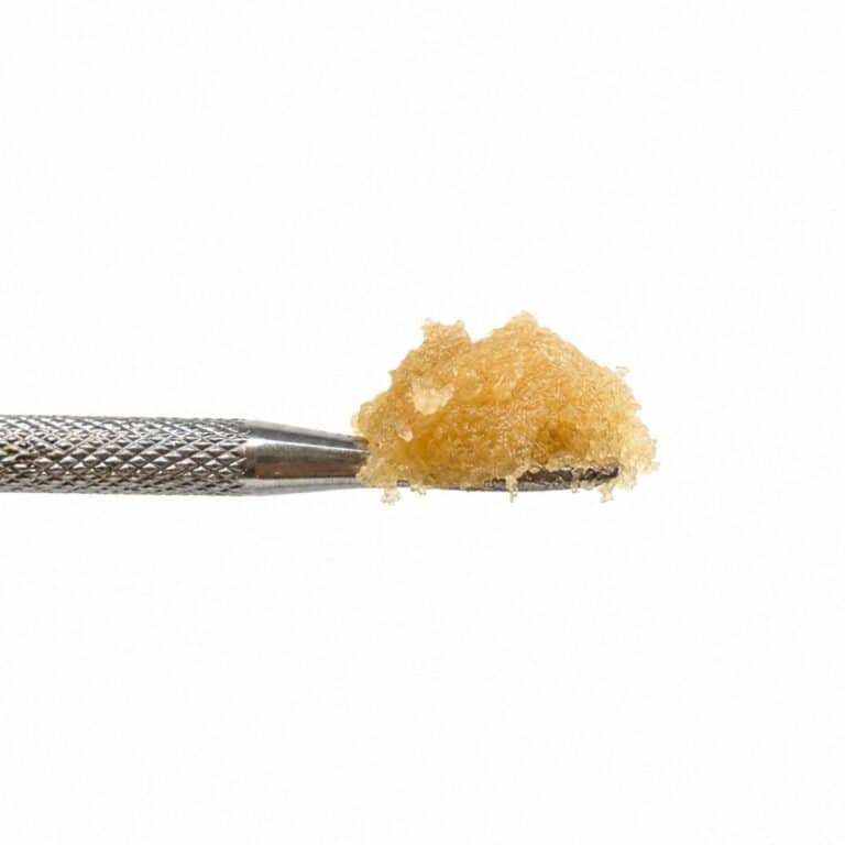 Ice Cream Cake Live Resin cannabis concentrate on a stainless steel dab tool with a golden terpene-rich extract against a white background.