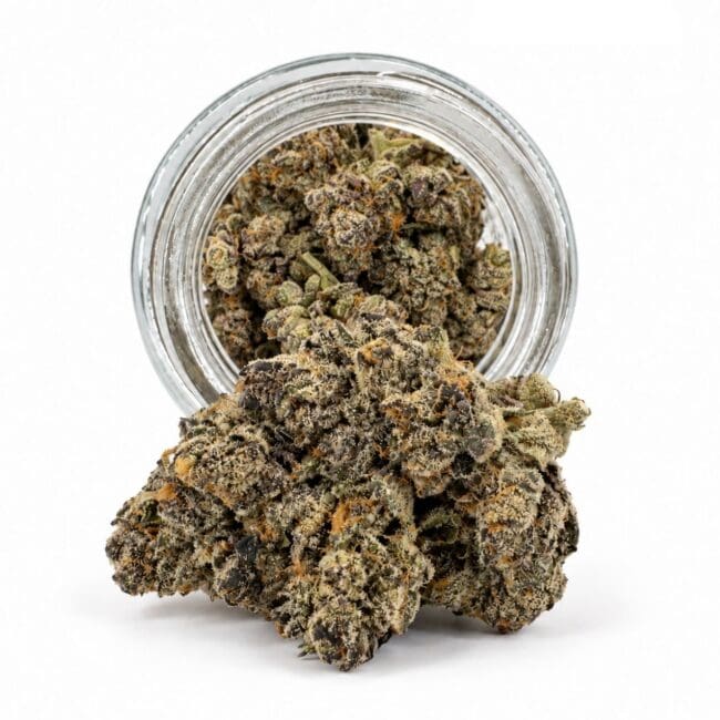 Dense cannabis flower with frosty trichomes in foreground, glass jar softly blurred on a crisp white background
